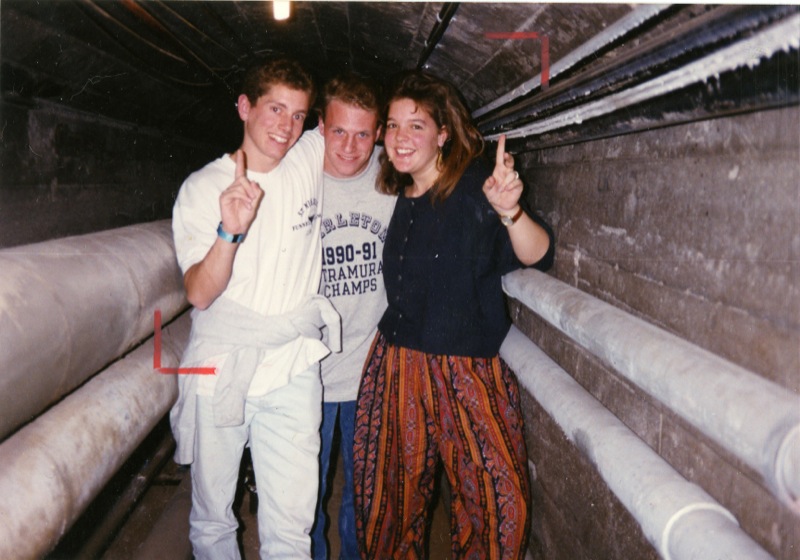 Colored photograph of three Carleton students posing inside of a tunnel